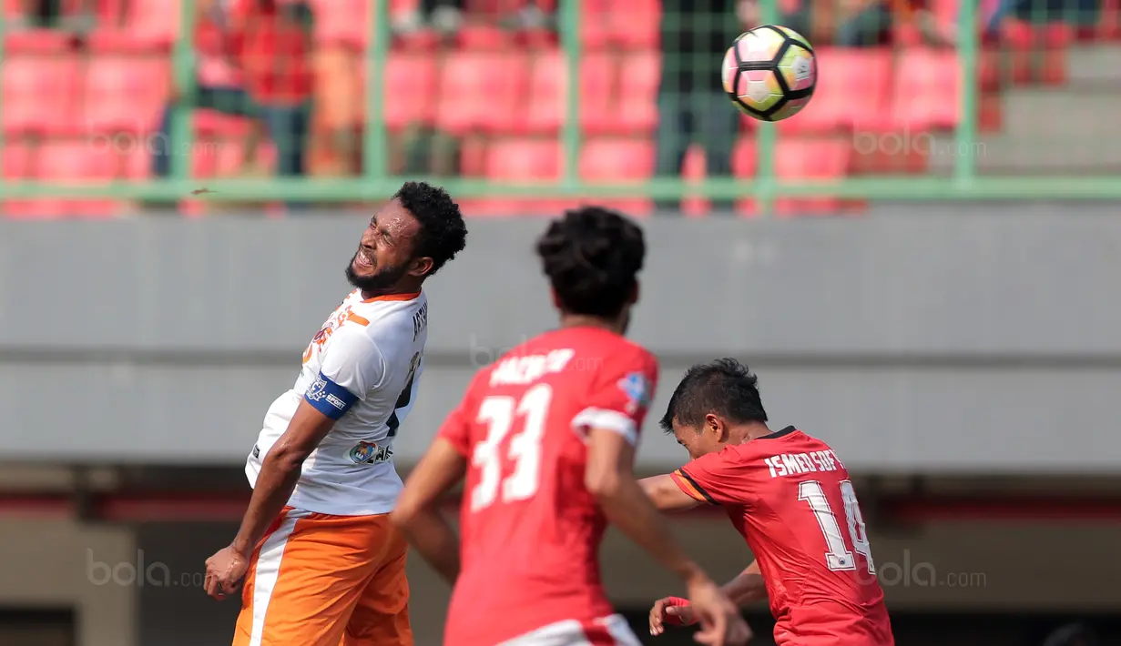 Kapten Perseru Serui, Arthur Bonai (kiri) membuang bola dari kejaran pemain Persija Jakarta pada lanjutan Liga 1 2017 di Stadion Patriot Bekasi, Selasa (19/9/2017). Persija menang 1-0. (Bola.com/Nicklas Hanoatubun)