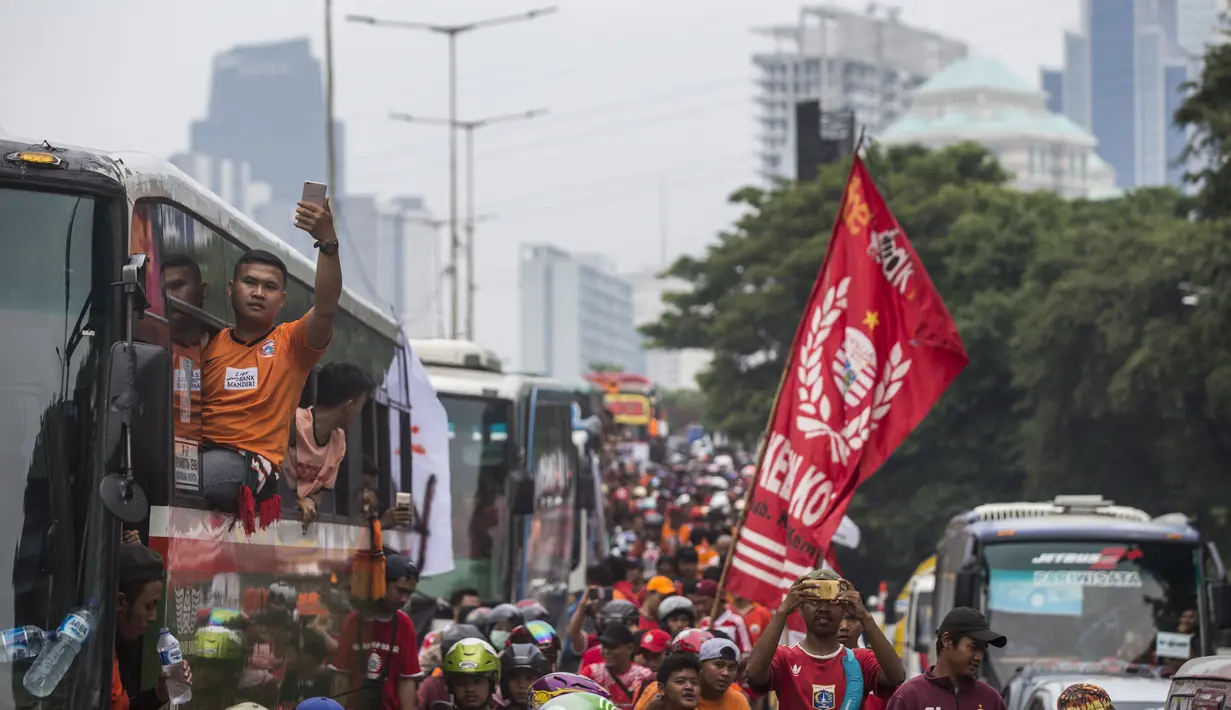 Suporter Persija Jakarta, The Jakmania, saat akan menonton laga Liga 1 melawan Mitra Kukar di Senayan, Jakarta, Minggu (9/12). Persija berpeluang besar menjadi juara jika berhasil menang. (Bola.com/Vitalis Yogi Trisna)