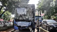 Polisi memeriksa kondisi Bus Transjakarta yang mengalami ringsek usai menabrak Pos Lantas PGC Cililitan, Jakarta Timur, Kamis (2/12/2021). Kecelakaan melukai seorang petugas. (merdeka.com/Iqbal S. Nugroho)