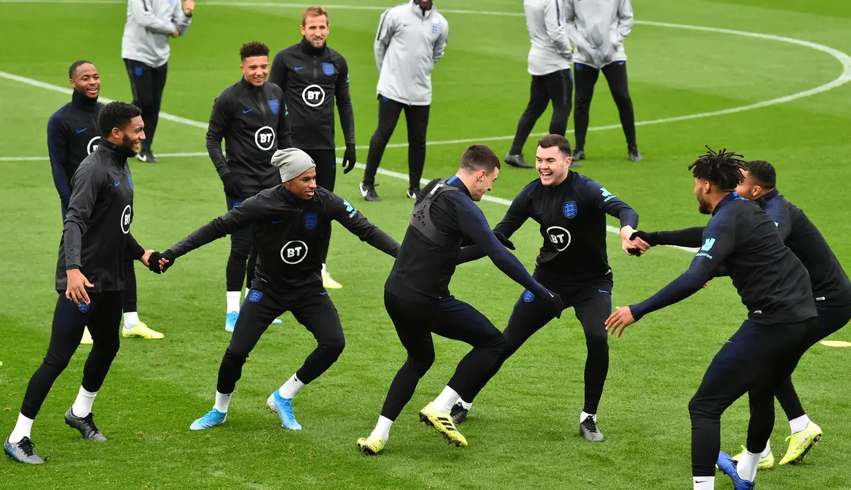 Para pemain Inggris tertawa saat bermain Kabaddi selama sesi pelatihan tim  di Staplewood Campus di southampton, Inggris selatan (9/9/2019). Inggris akan bertanding melawan Kosovo pada grup A Kualifikasi Euro 2020 di Stadion Saint Mary. (AFP Photo/Glyn Kirk)
