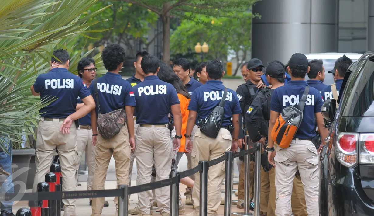 Sejumlah petugas kepolisian melakukan penjagaan selama proses rekonstruksi ulang pembunuhan Wayan Mirna Salihin di Kafe Olivier Grand Indonesia, Jakarta, (7/2).Selama proses rekonstruksi lokasi dijaga ketat oleh petugas. (Liputan6.com/Herman Zakharia)