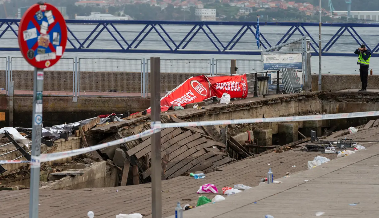 Petugas polisi mengambil foto di lokasi robohnya platform panggung dari kayu pada festival musik di tepi laut di Vigo, Spanyol, Senin (13/8). Penonton memenuhinya sampai sesak, dan akhirnya roboh sebelum tengah malam, Minggu (12/8). (AP/Lalo R. Villar)