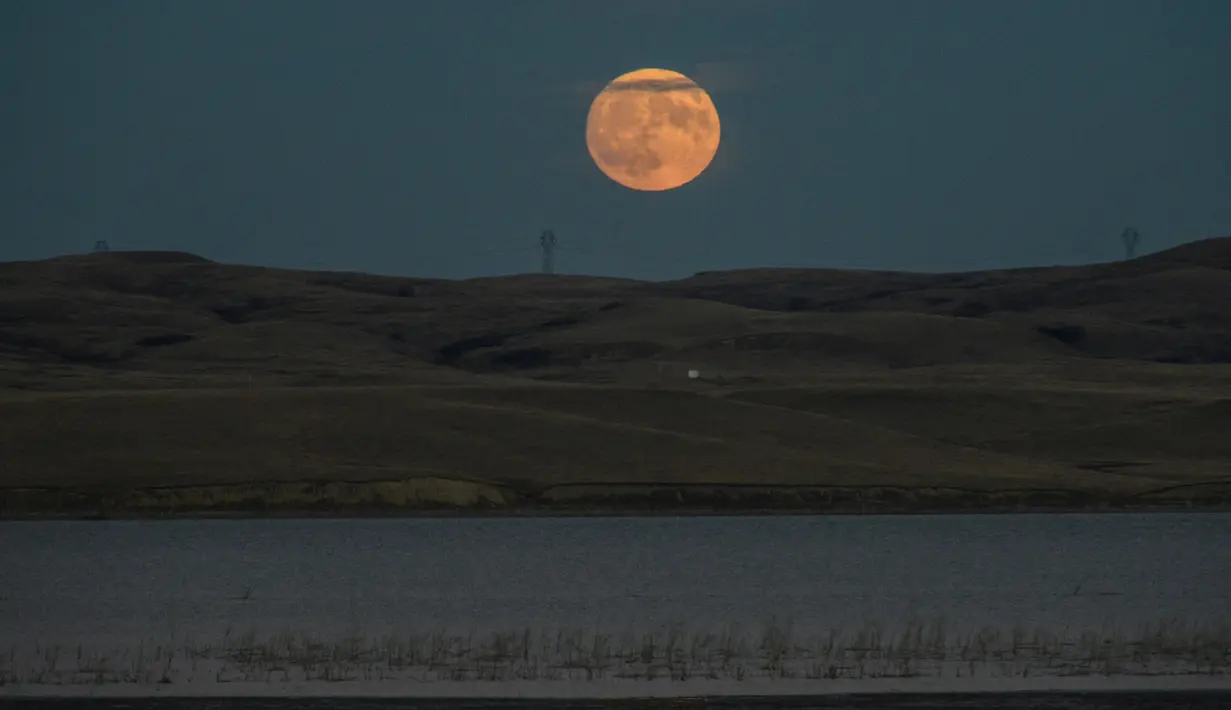 Fenomena Supermoon menghiasi Sungai Missouri di Cannon Ball, Dakota Utara, AS (13/11). Supermoon kali ini menjadi bulan purnama paling dekat ke bumi sejak 26 Januari 1948. (REUTERS/Stephanie Keith)