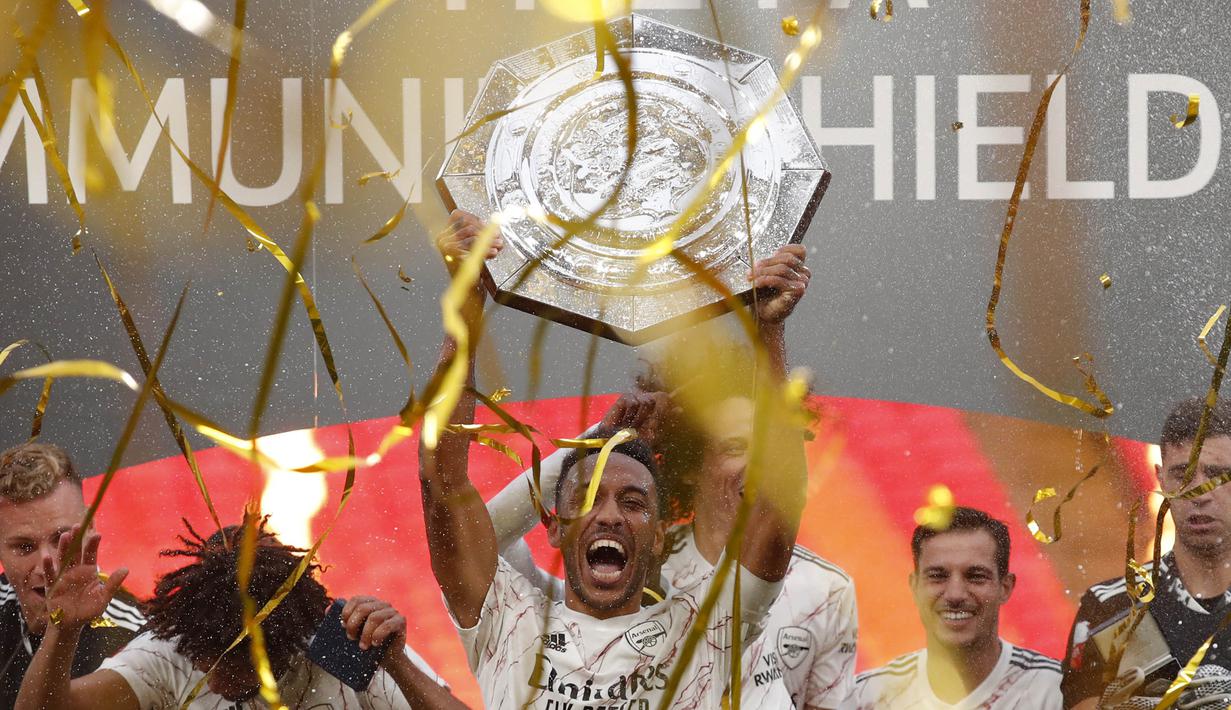 Striker Arsenal, Pierre-Emerick Aubameyang, mengangkat trofi juara Community Shield usai menaklukkan Liverpool di Stadion Wembley, Sabtu (29/8/2020). Arsenal menang adu penalti dengan skor 5-4. (Andrew Couldridge/Pool via AP)