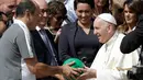Paus Fransiskus menandatangani bola dari anggota tim sepak bola Chapecoense di Vatikan (30/8). Dalam kunjungan ke Italia, tim Chapecoense akan bertanding melawan AS Roma. (AP Photo / Andrew Medichini)