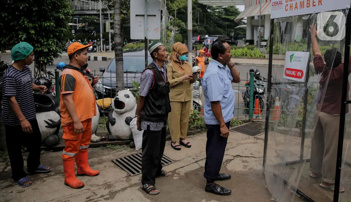 Warga mengantre masuk dalam ruang khusus semprot Desinfektan Chamber di depan Pasar Raya Blok M, Jakarta, Selasa (24/3/2020). Pamasangan ruang khusus semprot Desinfektan Chamber untuk mensterilkan full body masyarakat untuk menekan penyebaran Covid-19. (Liputan6.com/Faizal Fanani)