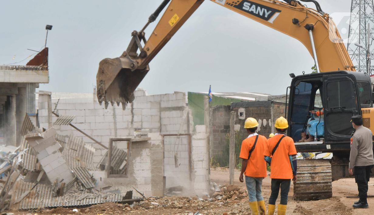 Petugas menggunakan alat berat saat pembebasan lahan proyek Jalan Tol CIbitung-CIlincing seksi 4 di kawasan Semper Timur, Cilincing, Jakarta Utara, Selasa (8/11/2022).  PT Cibitung Tanjung Priok Port Tollways (CTP Tollways) sebagai Badan Usaha Jalan Tol (BUJT) mencatat progres pembebasan lahan untuk seksi 4 sepanjang 7,28 km telah mencapai 100% dan ditargetkan pembangunannya selesai pada akhir tahun 2022. (Liputan6.com/Herman Zakharia)