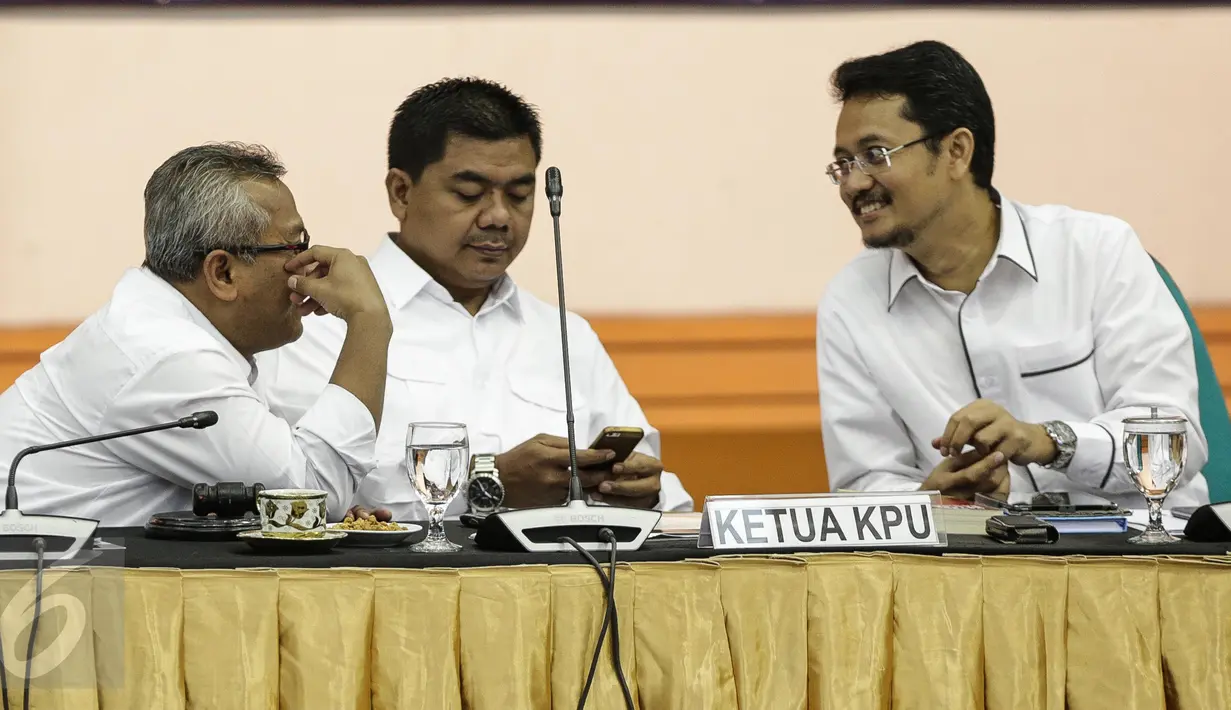 Ketua Komisi Pemilihan Umum (KPU), Juri Ardiantoro (tengah) bersama komisioner KPU, Ferry Kurnia Rizkiyansyah (kanan) dan Arief Budiman, berbincang sebelum memimpin rapat evaluasi di KPU Pusat, Jakarta, Selasa (4/4). (Liputan6.com/Faizal Fanani)