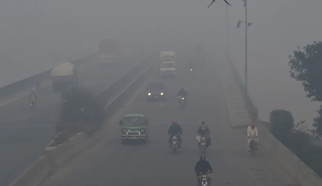 Kendaraan melintas di tengah kondisi kabut asap yang tebal di Lahore (21/11/2019). Selama kabut tebal pemerintah Pakistan menyarankan warga harus tetap berada di dalam rumah dengan jendela tertutup. (AFP Photo/Arif Ali)