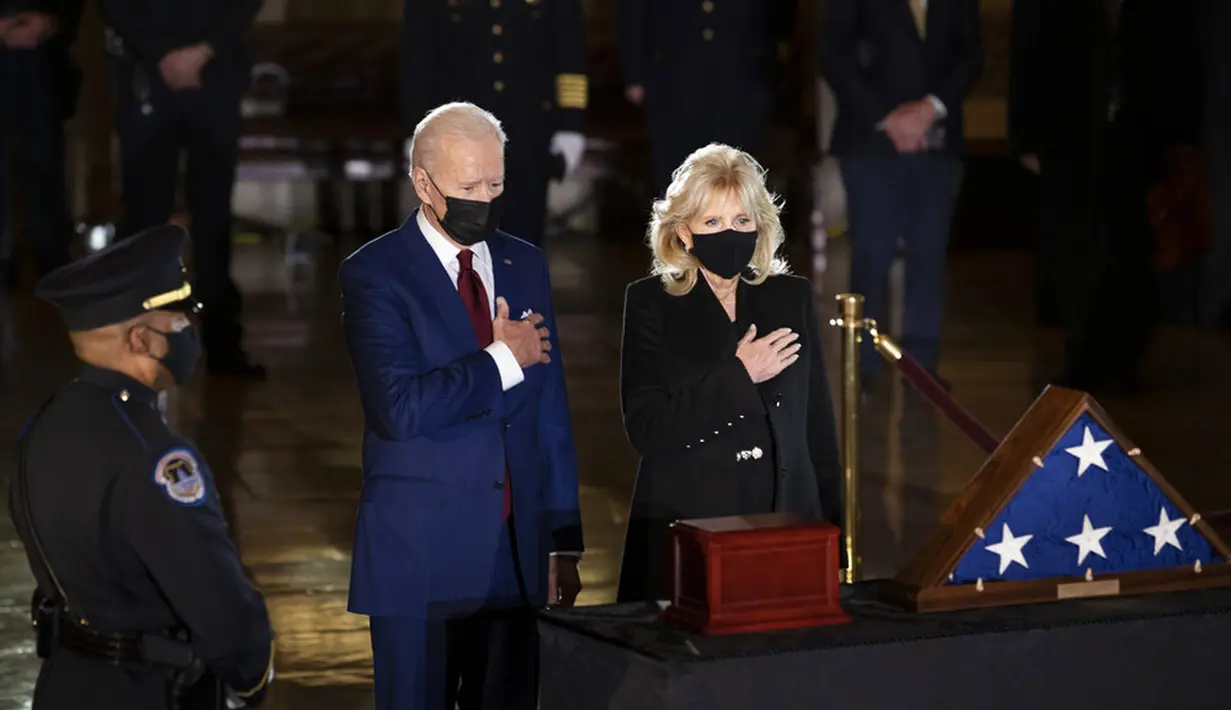 Presiden AS Joe Biden dan Ibu Negara Jill Biden memberi penghormatan kepada polisi yang tewas dalam kerusuhan Capitol Hill Brian Sicknick di tengah Capitol Rotunda, Washington, Selasa (2/2/2021). Abu jenazah Brian Sicknick dihadirkan dalam upacara ini. (Brendan Smialowski/Pool via AP)