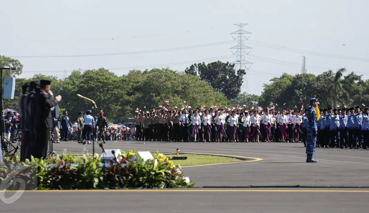 Sejumlah pegawai negri sipil, pramugari, pilot dan pasuka pramuka berpartisipasi dalam defile pada gladi HUT TNI di Taxi Way Skuadron Udara Bandara Halim Perdanakusumah, Jakarta, Minggu (9/4). (Liputan6.com/Faizal Fanani)