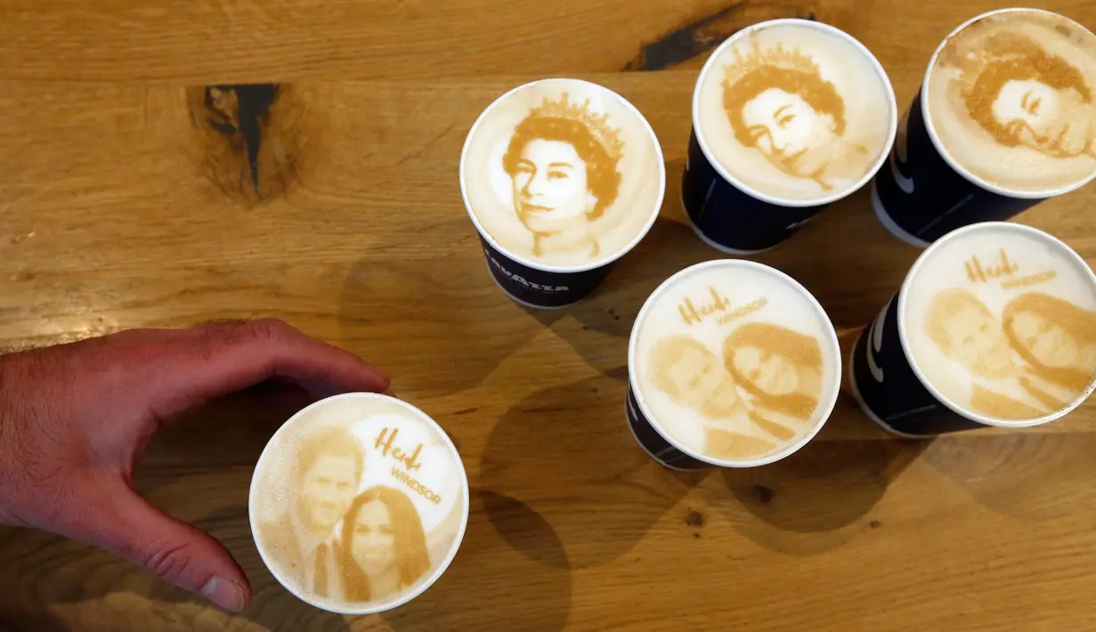 Seorang pria memegang kopi Capuccino dengan dengan latte art gambar Pangeran Harry dan Meghan Markle di kedai kopi, Windsor, 15 Mei 2018. Inggris sedang mempersiapkan pernikahan Harry dan Meghan pada 19 Mei mendatang di Windsor Castle. (AP/Frank Augstein)