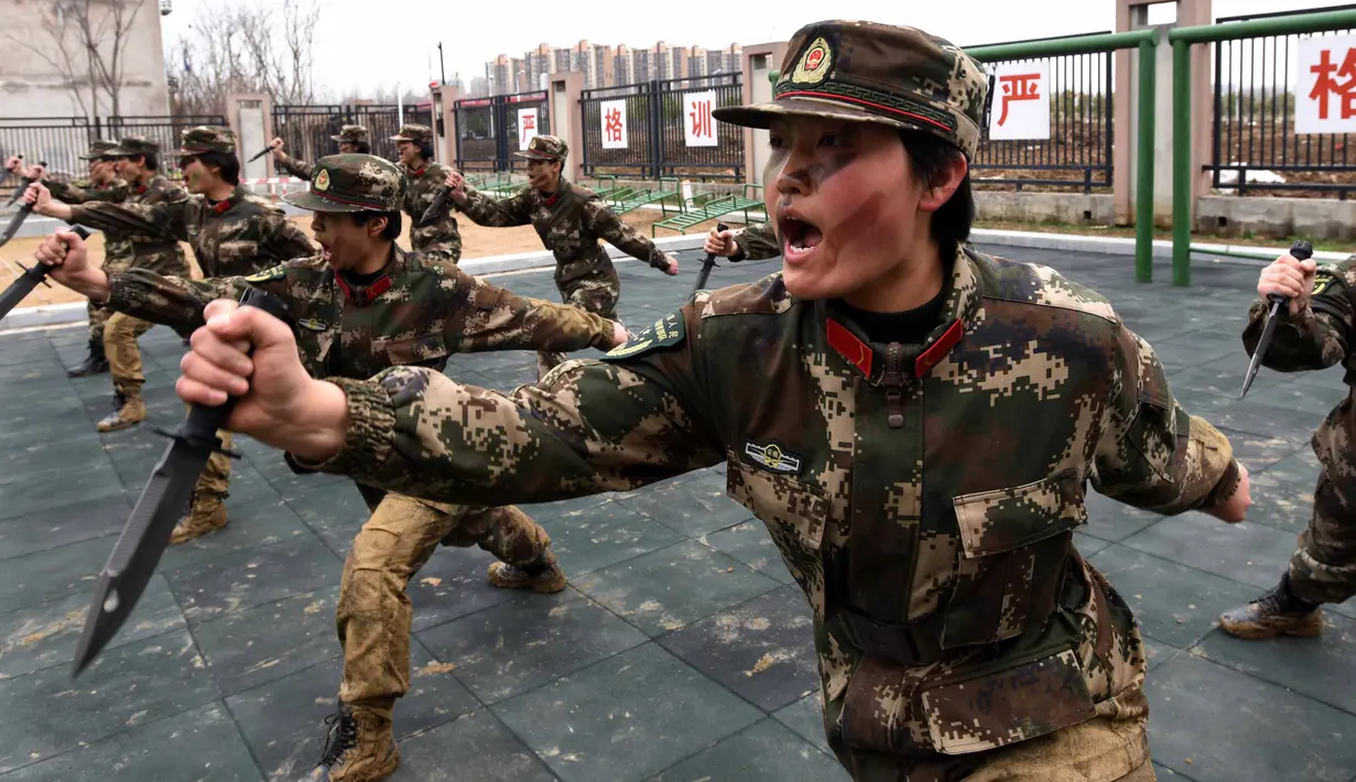 Tentara wanita China berlatih menggunakan pisau saat latihan militer jelang Hari Perempuan Internasional di Hefei, China (6/4). (AFP)