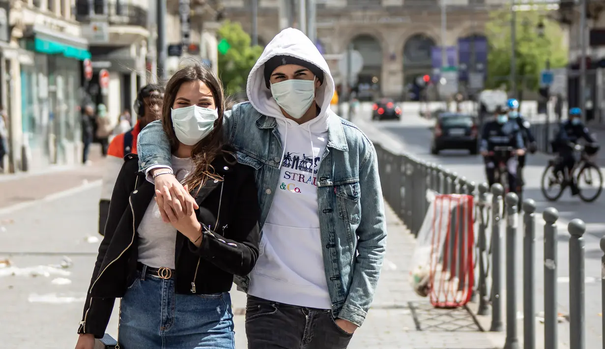 Pasangan mengenakan masker berjalan di Lille, Prancis utara, (11/5/2020). Prancis mulai melonggarkan pembatasan pergerakan mulai Senin (11/5) melalui "proses yang sangat bertahap" yang akan berlangsung selama beberapa pekan. (Xinhua/Sebastien Courdji)