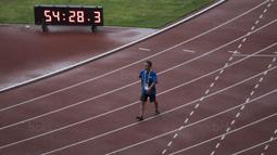 Seorang pekerja melewati lintasan lari di Stadion Utama Gelora Bung Karno, Jakarta, Jumat (9/8/2018). Lokasi ini akan dijadikan venue dari invitation tournament cabang atletik. (Bola.com/Vitalis Yogi Trisna)