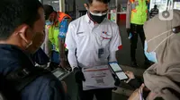 Petugas membantu calon penumpang memindai kode batang (QR Code) melalui aplikasi PeduliLindungi sebelum menaiki KRL di Stasiun Manggarai, Jakarta, Selasa (7/9/2021). PT KAI Commuter melakukan uji coba penggunaan aplikasi PeduliLindungi bagi pengguna KRL di 11 stasiun. (Liputan6.com/Faizal Fanani)