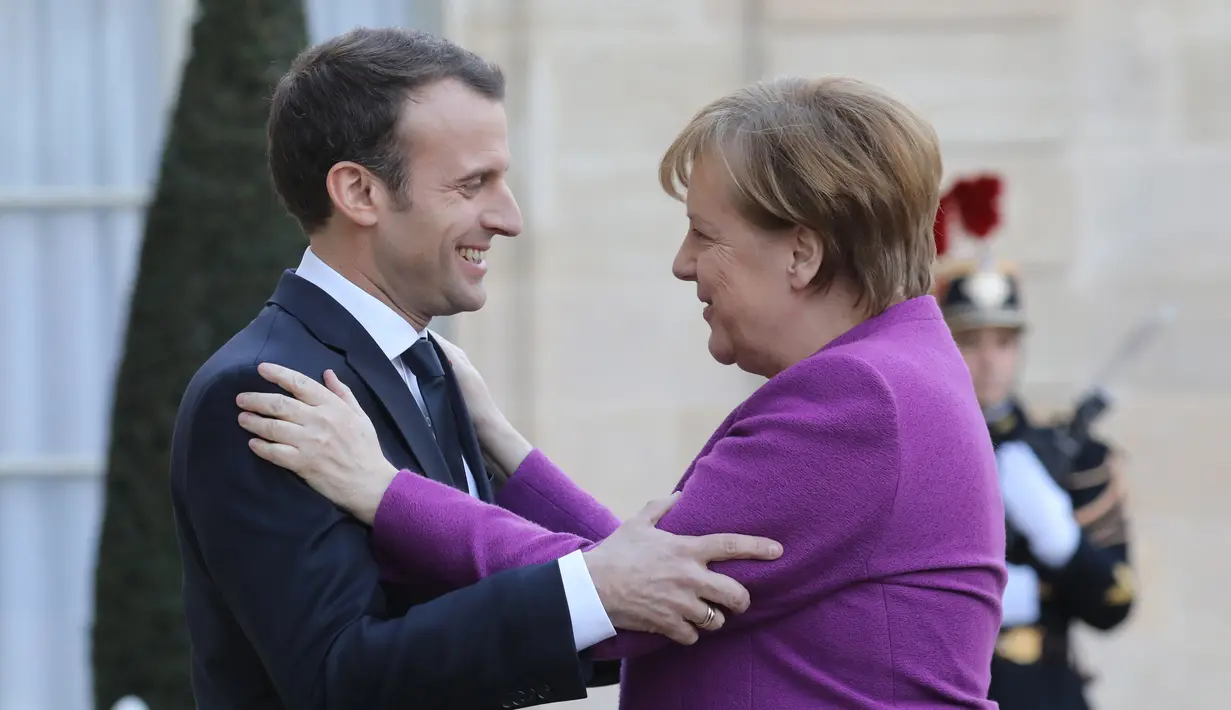 Presiden Prancis Emmanuel Macron (kiri) menyambut Kanselir Jerman Angela Merkel saat tiba di Istana Presiden Eylsee di Paris (16/3). Prancis ingin agar Uni Eropa menggunakan anggaran lebih besar untuk menggerakkan ekonomi. (AFP Photo/Ludovic Marin)