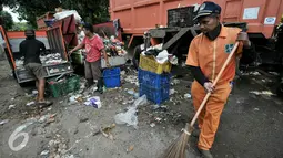 Pekerja memindahkan sampah ke truk pengangkut di Transit Pembuangan Sampah, Lenteng Agung, Jakarta, Senin (11/7). Pasca libur Lebaran, volume sampah di Kecamatan Jagakarsa  mencapai 200 ton. (Liputan6.com/Yoppy Renato)