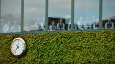 Staff restoran menyaksikan aksi pemain Serbia, Novak Djokovic saat berlatih sebelum melawan pemain Inggris Raya,  James Ward  pada Tenis Wimbledon Championships 2016 di The All England Lawn Tennis Club, Wimbledon,  London, (27/6/2016). (AFP/ Glyn Kirk)