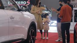 Pengunjung mulai berdatangan saat mulai memasuki siang hari. Sebuah keluarga muda dengan satu anak perempuan terlihat tertarik dengan New MG HS. Mereka berdiri di depannya dengan didampingi product expert MG yang siap menjelaskan apapun tentang mid-size SUV ini.