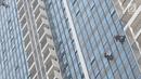 Pekerja membersihkan kaca gedung bertingkat di Jakarta, Kamis (18/10). Kepala Divisi Komunikasi BPJS Ketenagakerjaan Irvansyah Utoh Banja mengatakan, BPJS Ketenagakerjaan menargetkan kepesertaan BPJS Ketenagakerjaan 2018. (Liputan6.com/Immanuel Antonius)