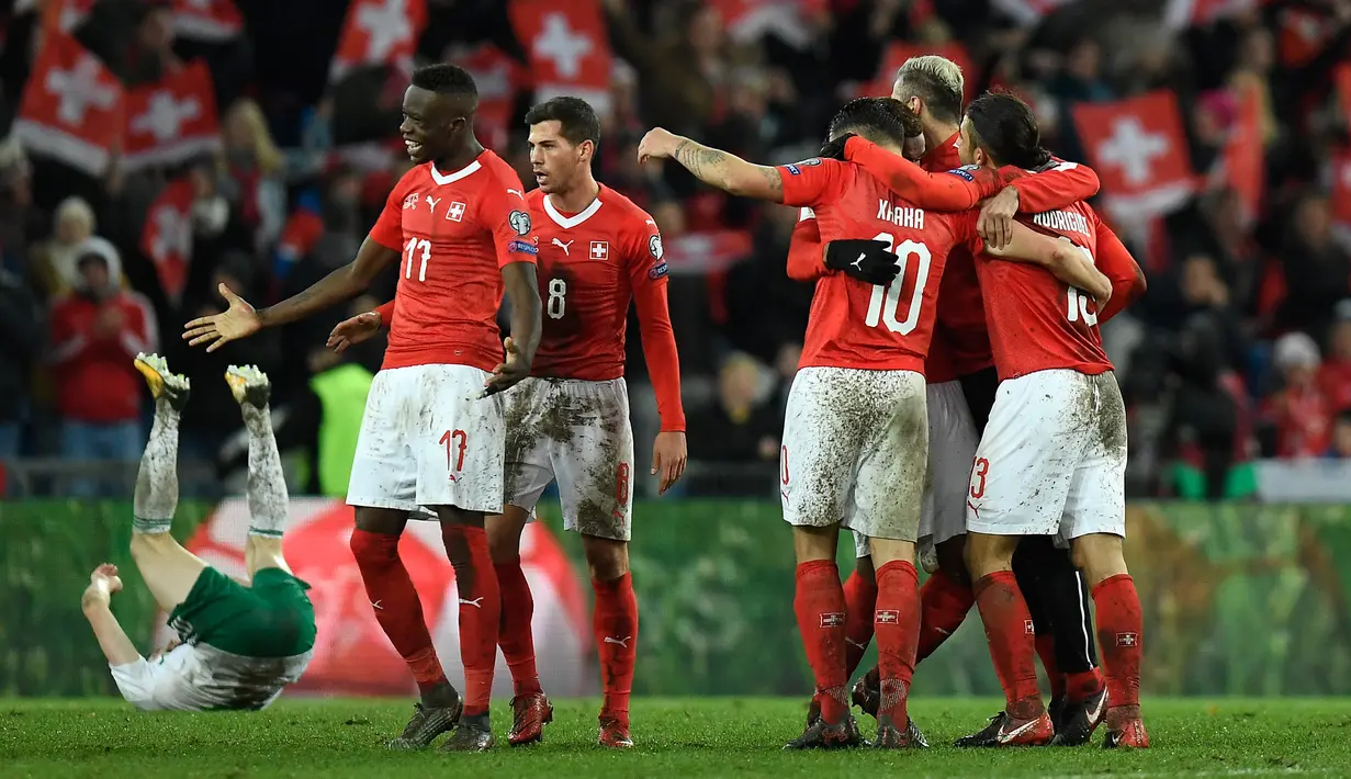 Pemain Swiss merayakan kemenangan atas Irlandia Utara  seusai leg kedua fase playoff Piala Dunia 2018 zona Eropa di St Jakob Park Stadium, Minggu (12/11). Swiss unggul agregat 1-0 atas Irlandia Utara. (Jean-Christophe Bott/Keystone via AP)