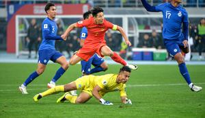 Aksi bintang Timnas China, Wu Lei (merah) saat menghadapi hadangan dari kiper Timnas Singapura, Hassan Sunny di putaran kedua Kualifikasi Piala Dunia 2026. (AFP).