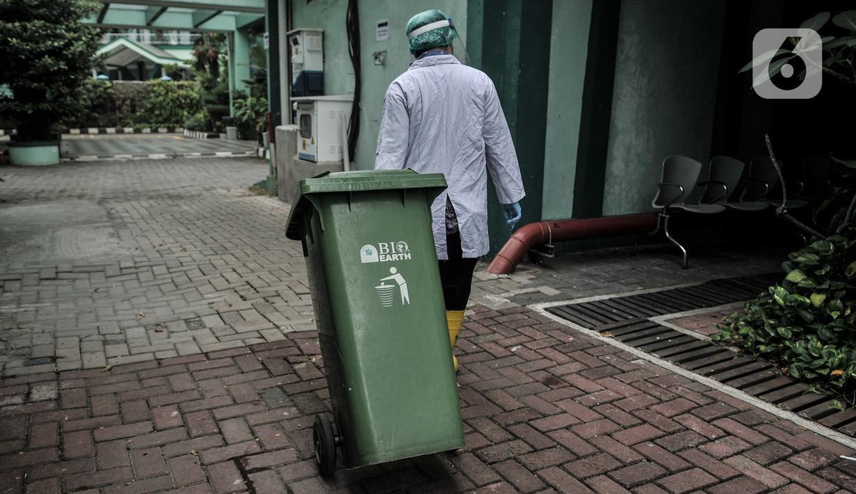Petugas membawa tong sampah berisi limbah Covid-19 di Tempat Penyimpanan Sementara Limbah B3 di Labkesda DKI Jakarta, Selasa (4/8/2020). Pembuangan limbah Covid-19 di Labkesda DKI Jakarta dilakukan dengan proses ketat sesuai protokol kesehatan. (merdeka.com/Iqbal Nugroho)
