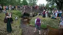 Sejumlah warga mengikuti Festival Rasos di Rumsiskes, Lithuania, Selasa (23/6/2020). Orang-orang merayakan festival ini dengan mengenakan sejumlah hiasan bunga dan kostum tradisional serta bernyanyi dan menari. (Xinhua/Alfredas Pliadis)