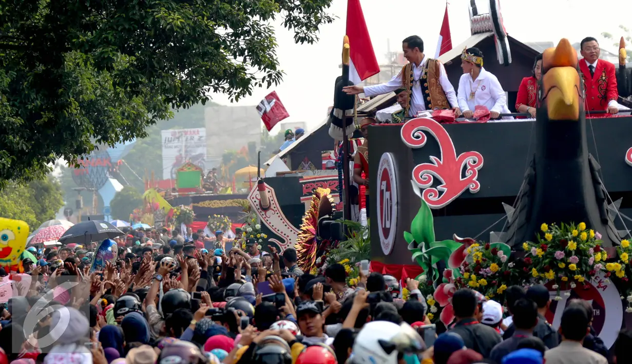 Presiden Joko Widodo melambaikan tangan ke warga dalam Festival Karnaval Khatulistiwa, Pontianak, Sabtu (22/8/2015).Pontianak menjadi tuan pertama Festival Karnaval Khatulistiwa yang diselenggarakan di luar Jakarta. (Liputan6.com/Faizal Fanani)