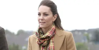 Ini saat Kate Middleton berkunjung ke Skontlandia, mengenakan long coat dari Massimo Dutti berwarna camel netral yang klasik dengan syal kotak-kotak Strathearn yang agak pop, dan celana high-waisted bernuansa senada. Foto: Bustle.