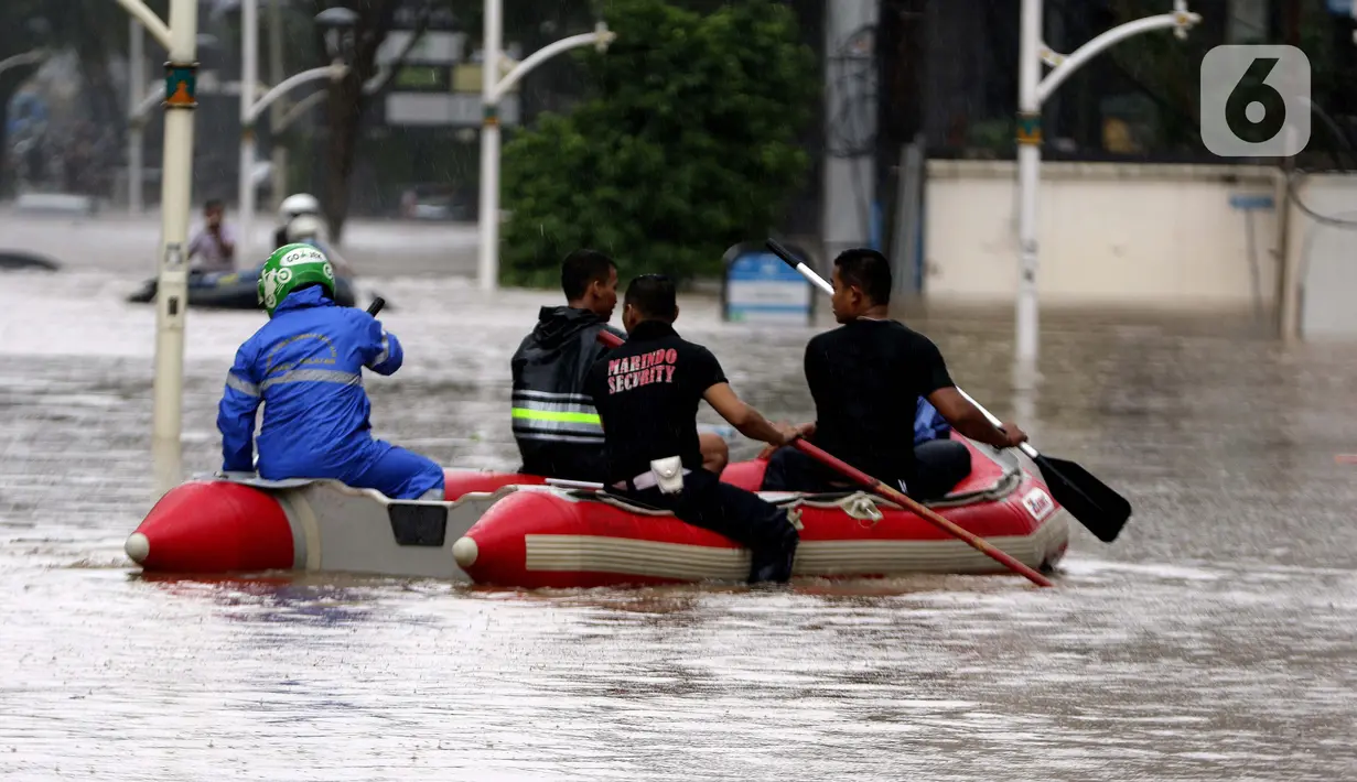 Petugas menggunakan perahu karet mengevakuasi beberapa warga yang terjebak banjir di kawasan Jalan Kemang Raya, Jakarta, Sabtu (20/2/2021). Hujan yang mengguyur Jakarta sejak Jumat (19/2) membuat sejumlah titik di Jakarta terendam banjir. (Liputan6.com/Helmi Fithriansyah)