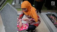 Menteri Sosial Khofifah Indar Parawansa menaburkan bunga di salah satu makam pahlawan di Taman Makam Pahlawan Kalibata, Jakarta, Senin (2/10). Mensos mengajak 50 santri penghafal Alquran untuk mendoakan para pahlawan nasional. (Liputan6.com/Faizal Fanani)