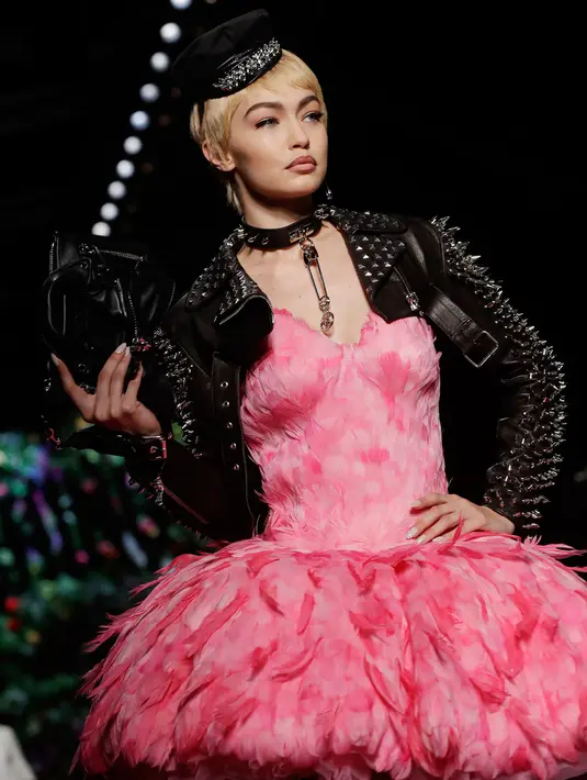 Model cantik asal Amerika Gigi Hadid tampil dengan busana koleksi rumah mode Moschino saat Milan Fashion Week di Italia, Kamis (21/9). Gigi Hadid tampil dengan gaun berbulu merah muda dipadukan jaket dan topi berwarna hitam. (AP Photo/Luca Bruno)
