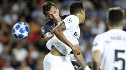 Striker Juventus, Mario Mandzukic, duel udara dengan bek Valencia, Jeison Murillo, pada laga Liga Champions di Stadion Mestalla, Valencia, Rabu (19/9/2018). Juventus menang 2-0 atas Valencia. (AP/Alberto Saiz)