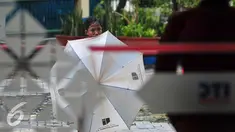 Seorang anak menunggu calon konsumen yang akan memakai jasa ojek payung, Jakarta, Selasa (1/11). Musim hujan dimanfaatkan sejumlah anak untuk mengais rezeki dengan mengojekkan payung. (Liputan6.com/Angga Yuniar)