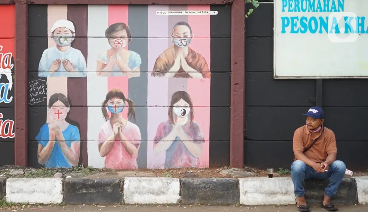 Warga duduk di dekat mural bergambar simbol orang berdoa menggunakan masker di kawasan Juanda, Kota Depok, Jumat (26/6/2020). Mural yang dibuat warga itu bertujuan memberi edukasi untuk menggunakan masker sebagai salah satu pencegahan dan penyebaran COVID-19. (Liputan6.com/Immanuel Antonius)