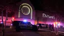 Polisi San Antonio berjaga di pintu keluar setelah terjadinya baku tembak di Rolling Oaks Mall, Texas, Minggu (22/1). Satu orang tewas dan tujuh orang lainnya mengalami luka tembak, termasuk salah satu tersangka. (AP Photo/Eric Gay)