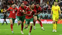 Maroko berhasil mencetak sejarah baru dengan finis di peringkat keempat Piala Dunia 2022. Skuad berjuluk Singa Atlas tersebut secara mengejutkan mampu menaklukkan negara-negara unggulan Eropa seperti Belgia, Spanyol, dan Portugal. Atas penampilan gemilang anak asuh Walid Regragui, Maroko berhasil menjadi tim dengan kenaikan peringkat FIFA paling tinggi. Hakimi dan kolega yang awalnya menduduki peringkat ke-22 naik sebelas tingkat menjadi peringkat ke-11. (AFP/Javier Soriano)
