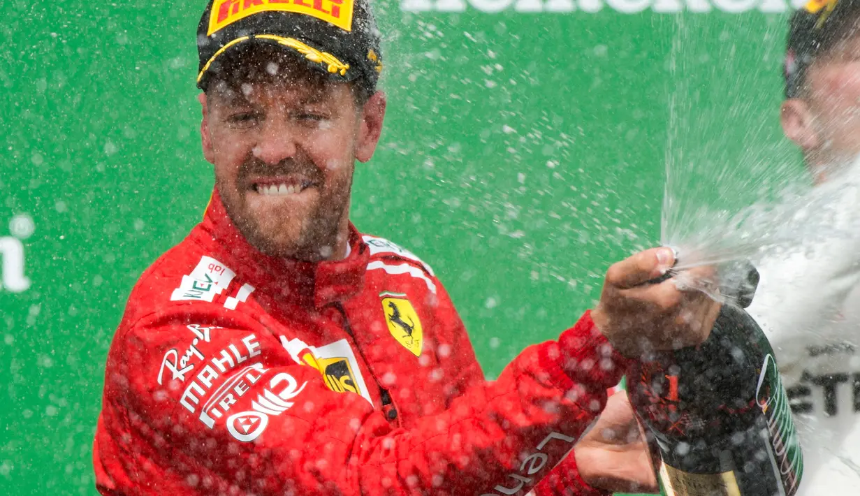 Pembalap Ferrari, Sebastian Vettel merayakan kemenangannya dalam F1 GP di Montreal, Kanada, Minggu (10/6). Kemenangan Vettel terasa spesial buat Ferrari karena meraih kemenangan perdana di seri Kanada setelah 2004. (Ryan Remiorz/The Canadian Press via AP)