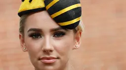 Ella Reese berpose dengan topi atau fascinator unik bermotif lebah saat menghadiri ajang pacuan kuda Royal Ascot di Ascot, Inggris, Selasa (18/6/2019). Royal Ascot menjadi ajang bagi wanita Inggris untuk tampil dengan fascinator unik. (AP Photo/Alastair Grant)