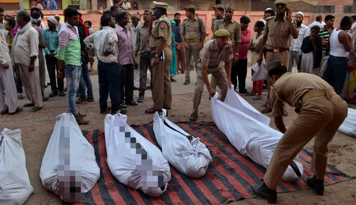 Petugas kepolisian mengatur mayat korban di luar rumah sakit di Etah, India, Jumat (5/5). Truk yang membawa sejumlah orang usai kembali dari upacara pernikahan mengalami kecelakaan jatuh ke sungai. (AFP/STR)