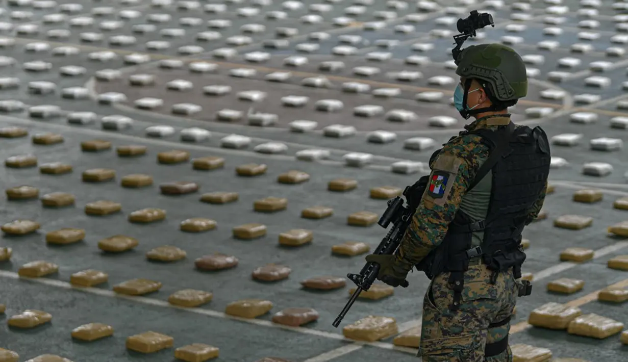 Anggota Layanan Perbatasan Nasional Panama menjaga paket ganja sitaan saat konferensi pers di Pangkalan Senafront Gamboa, Panama City, Panama, 1 September 2019. Militer Panama menyita 785 kilogram ganja selama operasi antinarkotika di perbatasan maritim dengan Kolombia. (Luis Acosta/AFP)