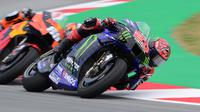 Fabio Quartararo sempat mengambil alih predikat pimpinan balapan, namun Oliveira tidak menyerah. Di lap 14, Oliviera memanfaatkan trek lurus untuk balik menyalip Quartararo. (Foto: AFP/Lluis Gene)