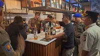 Satpol PP Kota Tangerang Selatan (Tangsel) menggelar razia minuman keras di sejumlah kafe, warung jamu dan toko kelontong pada Sabtu (11/2/2023) malam hingga Minggu (12/2/2023) dini hari. (Dok. Liputan6.com/Pramita Tristiawati)