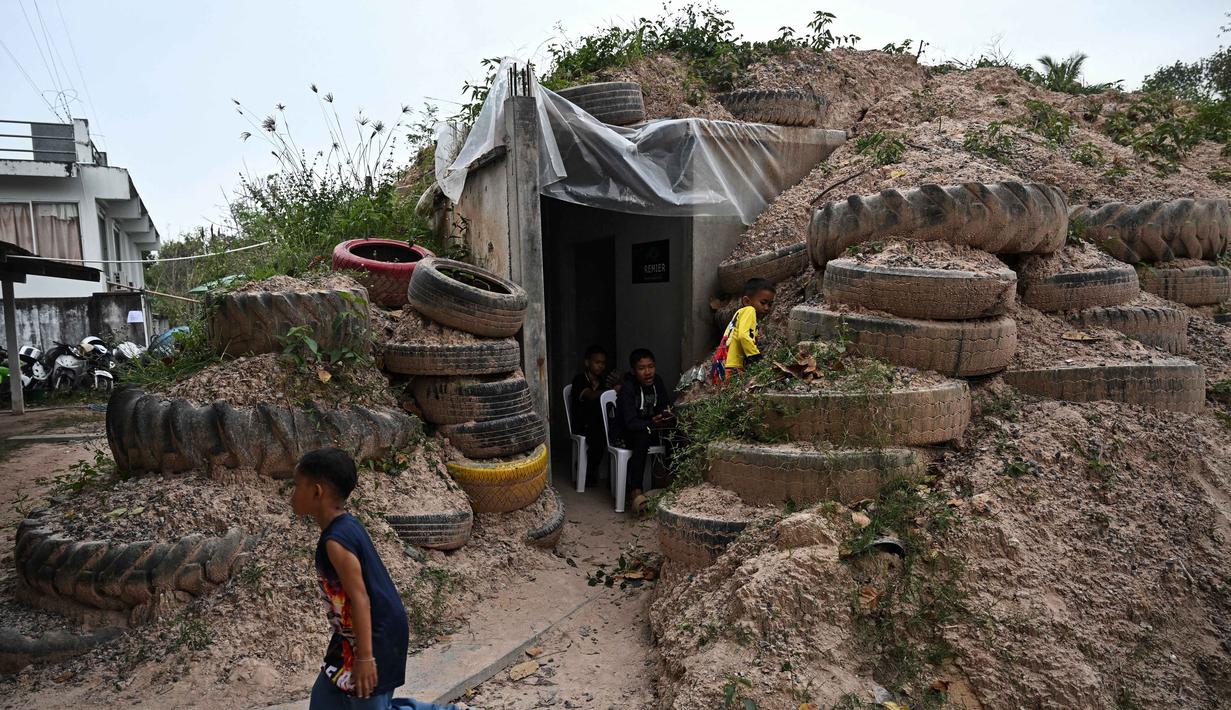 Jumlah ini melampaui total orang yang dievakuasi selama bentrokan serupa awal tahun ini. Tampak dalam foto, anak-anak bermain di sekitar bunker di provinsi Surin pada Rabu 10 Desember 2025, selama bentrokan di sepanjang perbatasan Thailand-Kamboja. (Lillian SUWANRUMPHA/AFP)