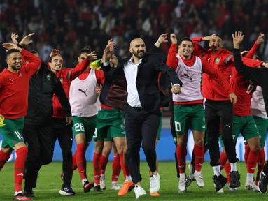 Pelatih Maroko Walid Reragui (Tengah) dan para pemainnya menyapa para suporter setelah laga uji coba internasional melawan Brasil di Grand Stade de Tanger, Tangier, Minggu (26/3/2023) pagi WIB. Timnas Maroko kembali membuat kejutan dengan membungkam Brasil 2-1. (Photo by Fadel Senna / AFP)