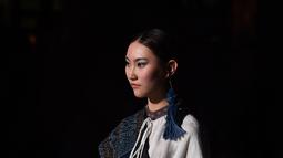 Seorang model memeragakan kreasi busana yang terbuat dari brokat Li, pakaian tradisional yang dibuat oleh kelompok etnis Li, dalam sebuah peragaan busana di Haikou, Provinsi Hainan, China selatan, pada 19 November 2020. (Xinhua/Guo Cheng)