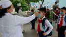 Siswa sekolah dasar Kim Song Ju diperiksa suhu tubuhnya sebelum memasuki sekolah di Pyongyang, Korea Utara, Rabu (3/6/2020). Korea Utara membuka kembali sekolah - sekolah di negara itu pada bulan ini setelah sebelumnya meliburkan karena kekhawatiran penyebaran virus corona. (AP/Jon Chol Jin)