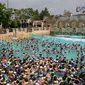 Wisatawan bermain air di water park yang dikenal dengan Caribbean Bay di Yongin, luar Seoul, Senin (6/8). Gelombang panas yang melanda Korea Selatan akhir-akhir ini membuat ratusan warga memenuhi kolam renang untuk mengurangi hawa panas. (Ed JONES/AFP)